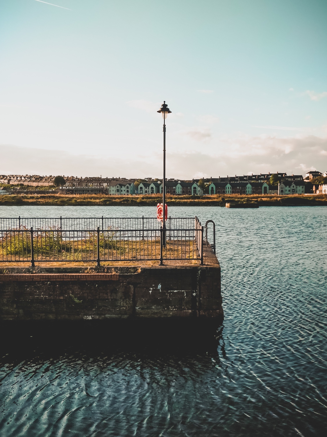 A singular lamp sits on an outcrop in the docks