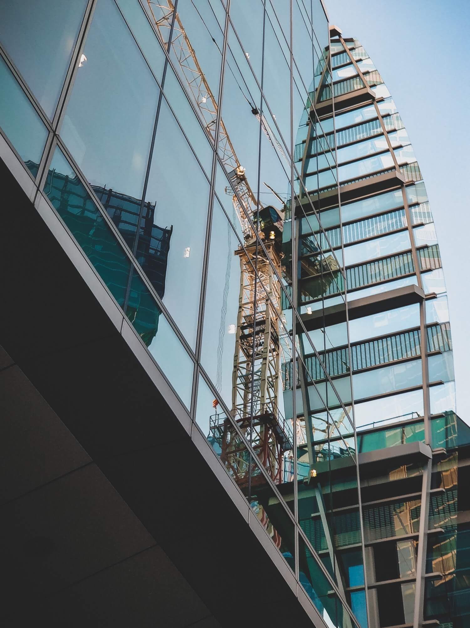 Reflection of a crane in a skyscraper